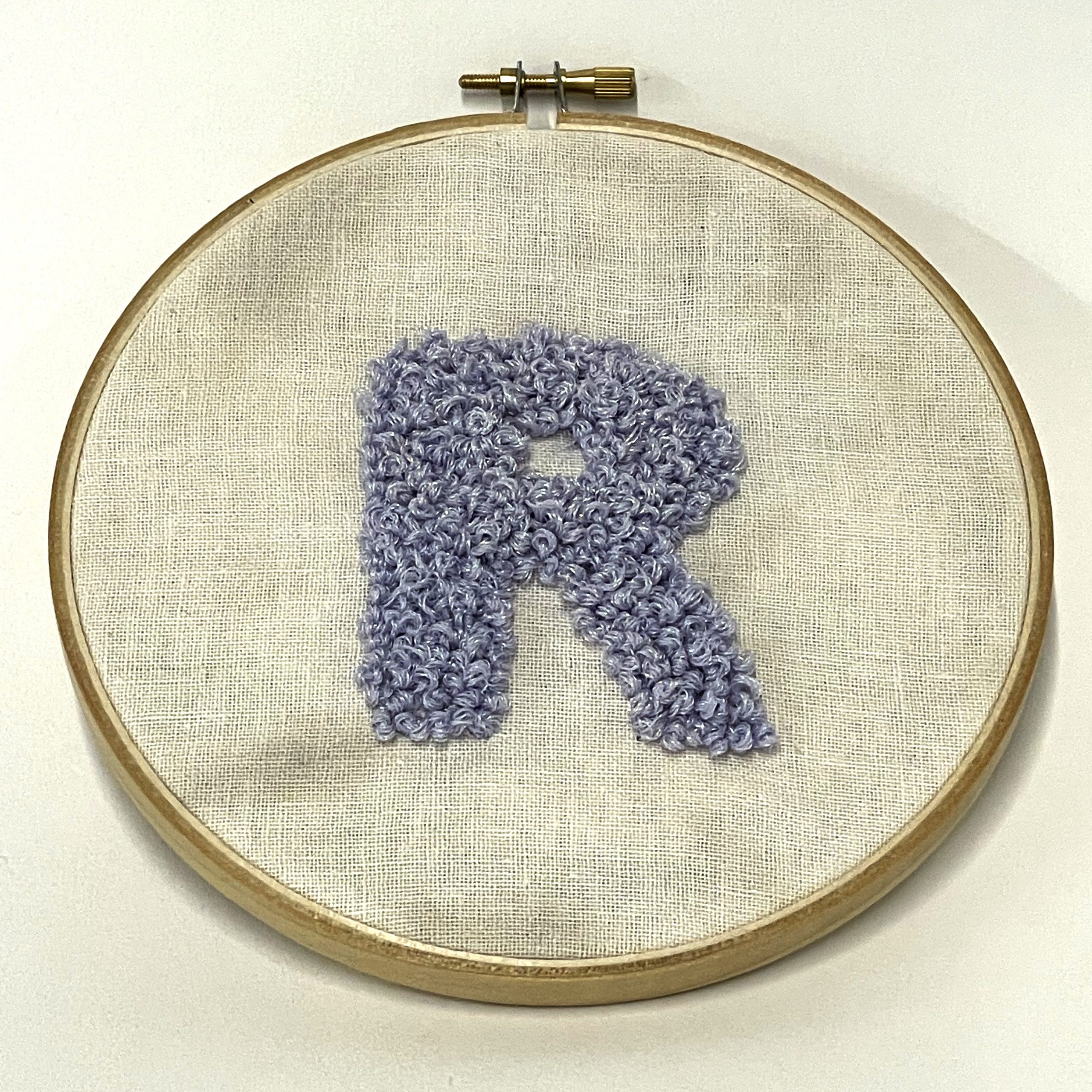 An embroidered R that's made with purple string